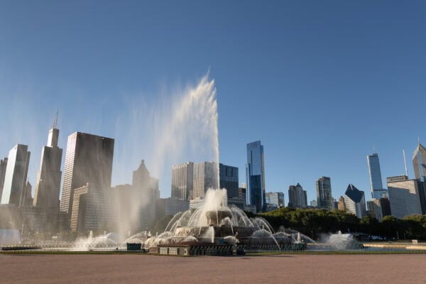 Buckingham Fountain in Chicago sprays high on a sunny day in front of the skyline