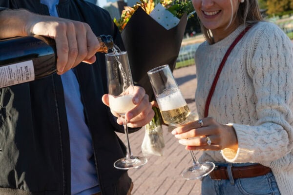 couple pours champagne in celebration of their engagement in Chicago