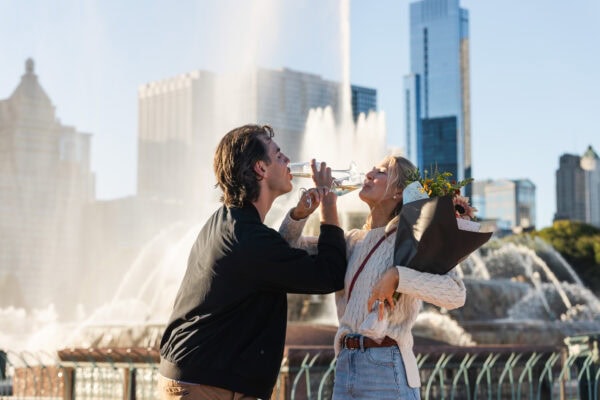 Couple Drinks Champagne in celebration of just getting engaged at the Chicago Buckingham Fountain