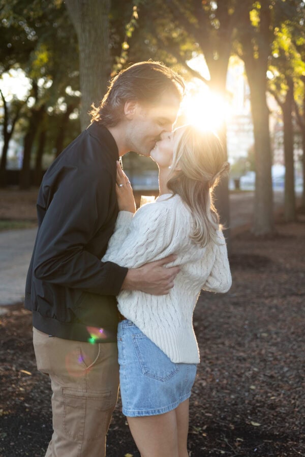 couple poses for an engagement photo at golden hour after just having a surprise proposal