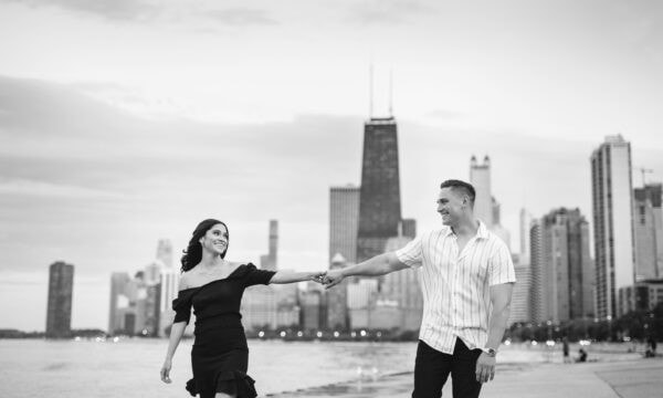 couple holds hands and walks on the platform on North Avenue beach in Chicago