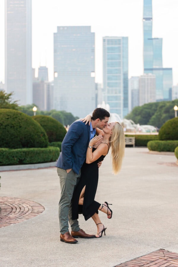 Engaged couple showing off the ring at buckingham fountain Chicago at sunset after their surprise proposal.