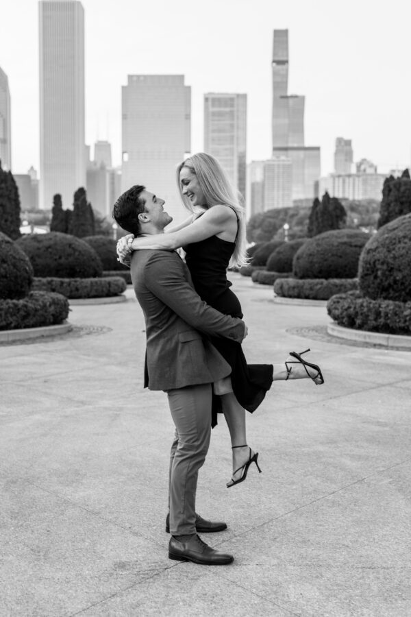Engaged couple embracing while showing off an engagement ring after a joyful surprise proposal.