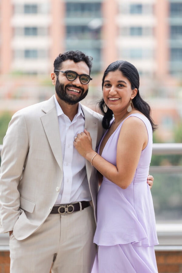 a well dressed couple poses for a photo after getting engaged