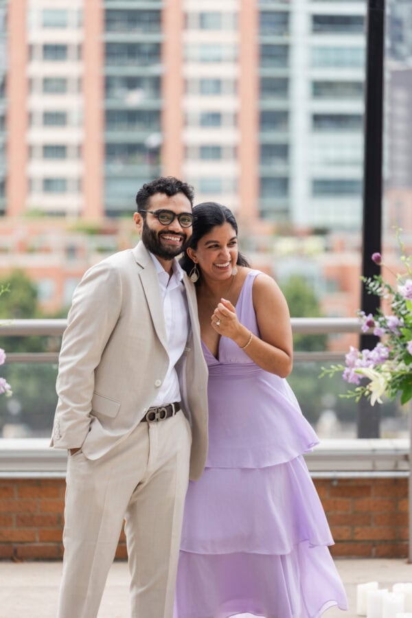 a newly engaged couple shares a glance just moments after the man proposed on a chicago rooftop