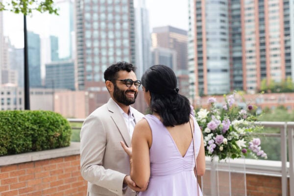 a newly engaged couple shares a glance just moments after the man proposed on a chicago rooftop