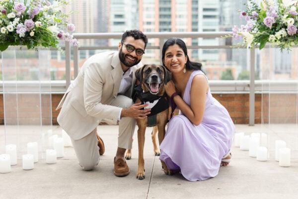 a newly engaged couple posed for a photo with their dog