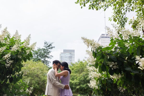 a newly engaged couple embrace in a chicago garden on a summer day