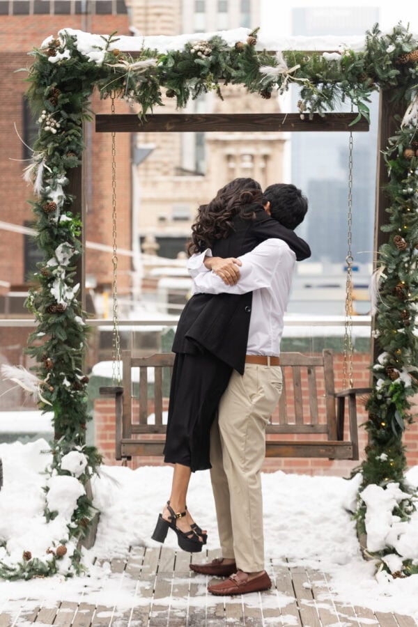 a man hugs his fiance on the rooftop of the Pendry in Chicago in the winter