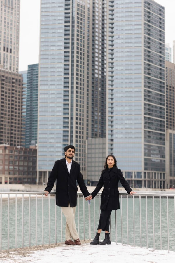 a couple shares a hug while posing for engagement photos at Olive Park in Chicago on a winter day