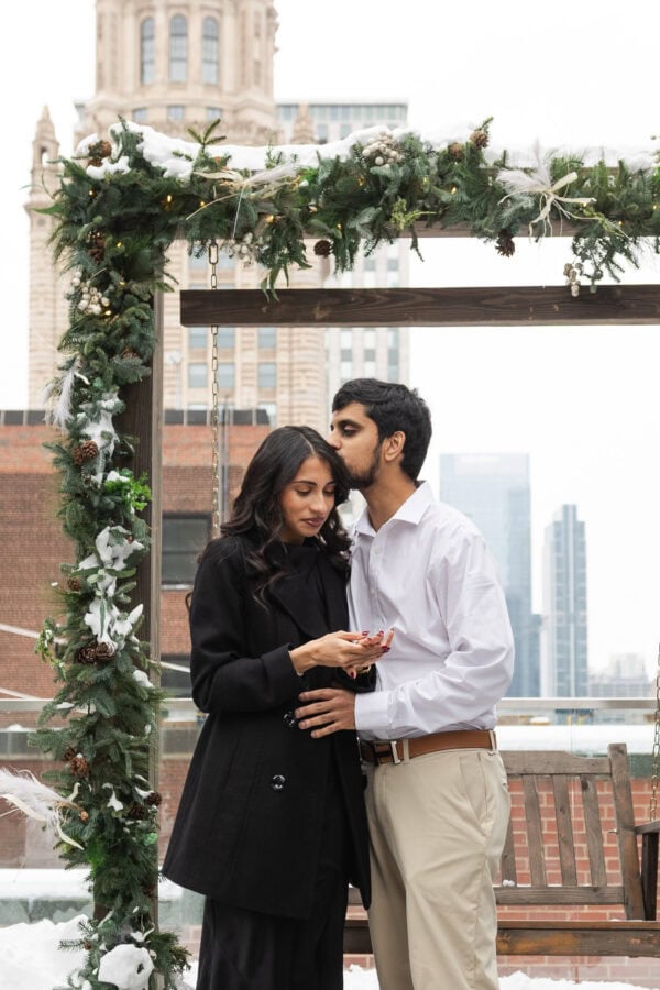 A newly engaged couple celebrates on the rooftop of the Pendry in Chicago in the winter
