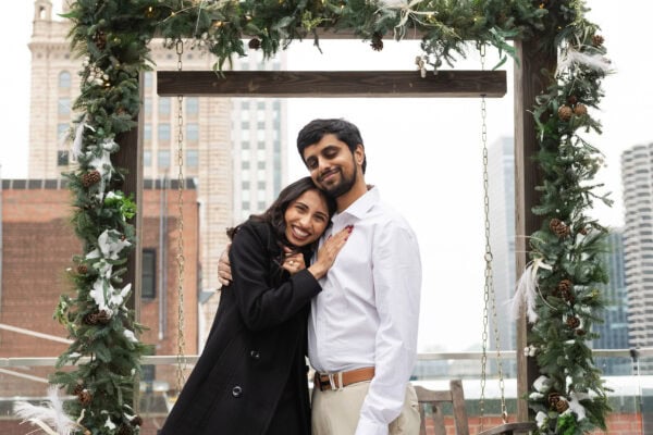 a couple shares a hug after being proposed to on the rooftop of the Pendry in Chicago in the winter