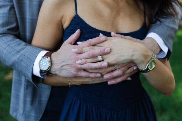 a man and womens arms embrace showing off her new engagement ring