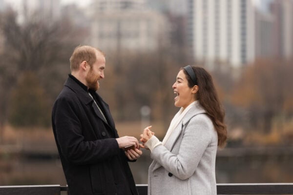 a newly engaged couple shares an excited moment as they look at each other in surprise 