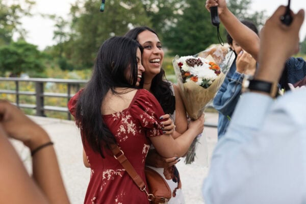 two friends embrace in celebration after one of them had just gotten engaged
