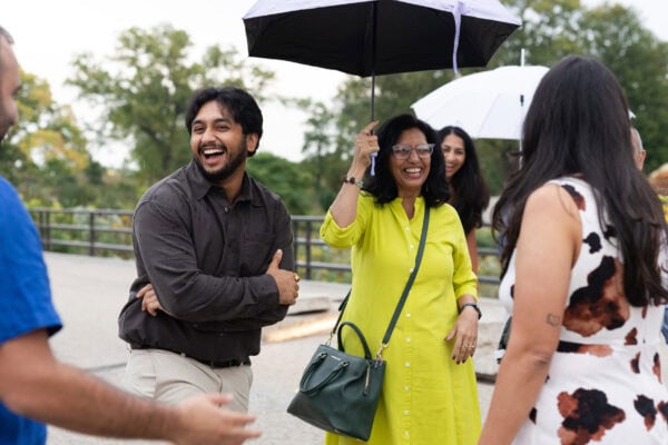 a family laughs while in conversation standing in a circle