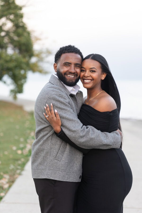 a newly engaged couple poses for a photo in Chicago at the lakefront at montrose harbor