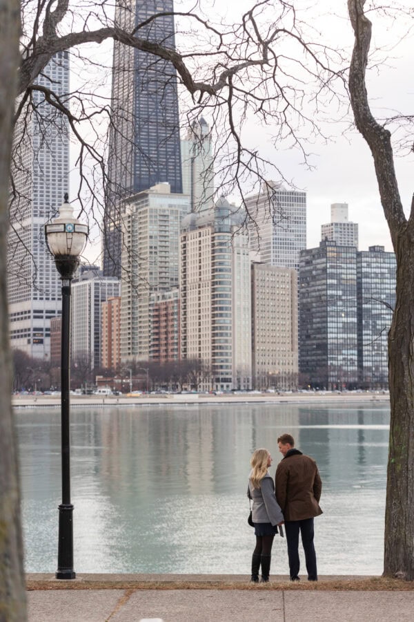 Newly engaged couple overlooks Lake Michigan and Chicago's skyline after a surprise proposal.