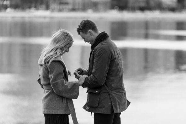 Groom-to-be places an engagement ring on his fiancée's finger moments after proposing in Chicago.