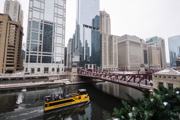 a boat is floating on the chicago river during the winter as it gives an architectural tour