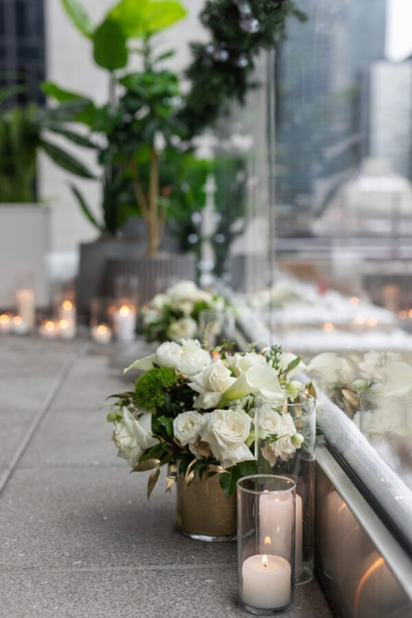The RPM Seafood terrace on the chicago river is decorated for a Surprise proposal with winter snow, candles and white rose arrangements.