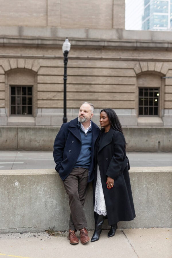 a couple poses for a photo downtown Chicago after just getting engaged. 