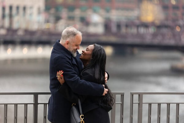 a couple shares a moment after just getting engaged on the Chicago River