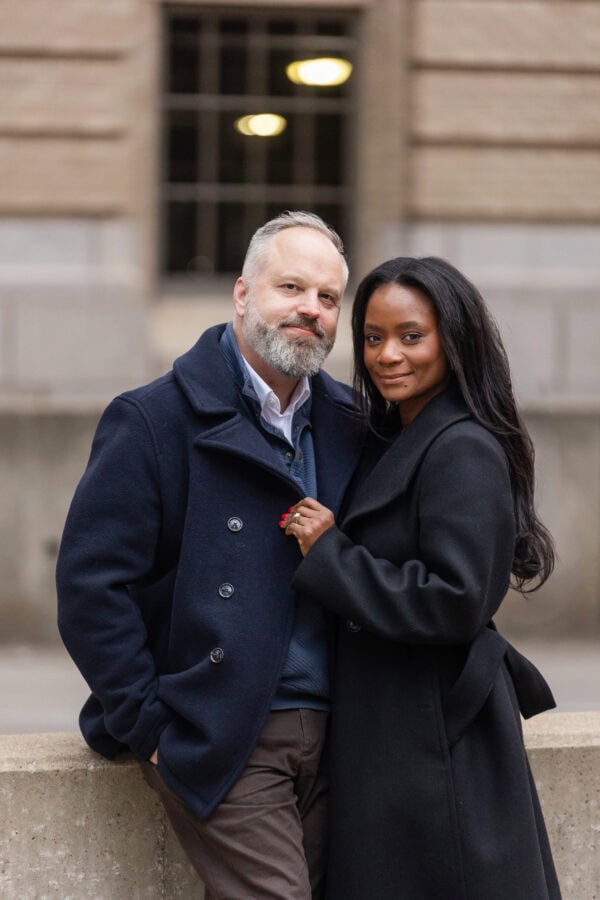 a couple poses for a photo downtown Chicago after just getting engaged. 